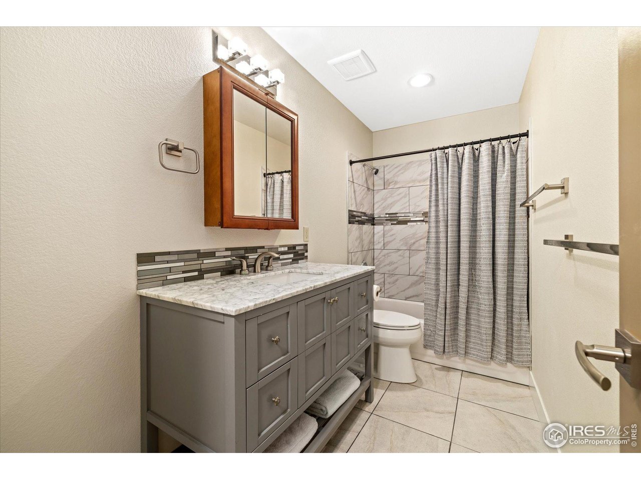 403 Double Tree Drive Greeley, CO 80634 - Photo 37 of 49 a bathroom with a granite countertop sink toilet a mirror and shower