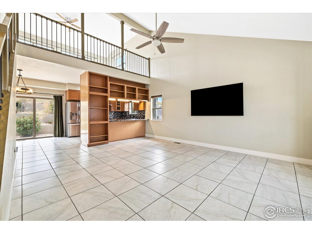 403 Double Tree Drive Greeley, CO 80634 - Photo 7 of 49 a view interior of a house with wooden floor a ceiling fan and windows