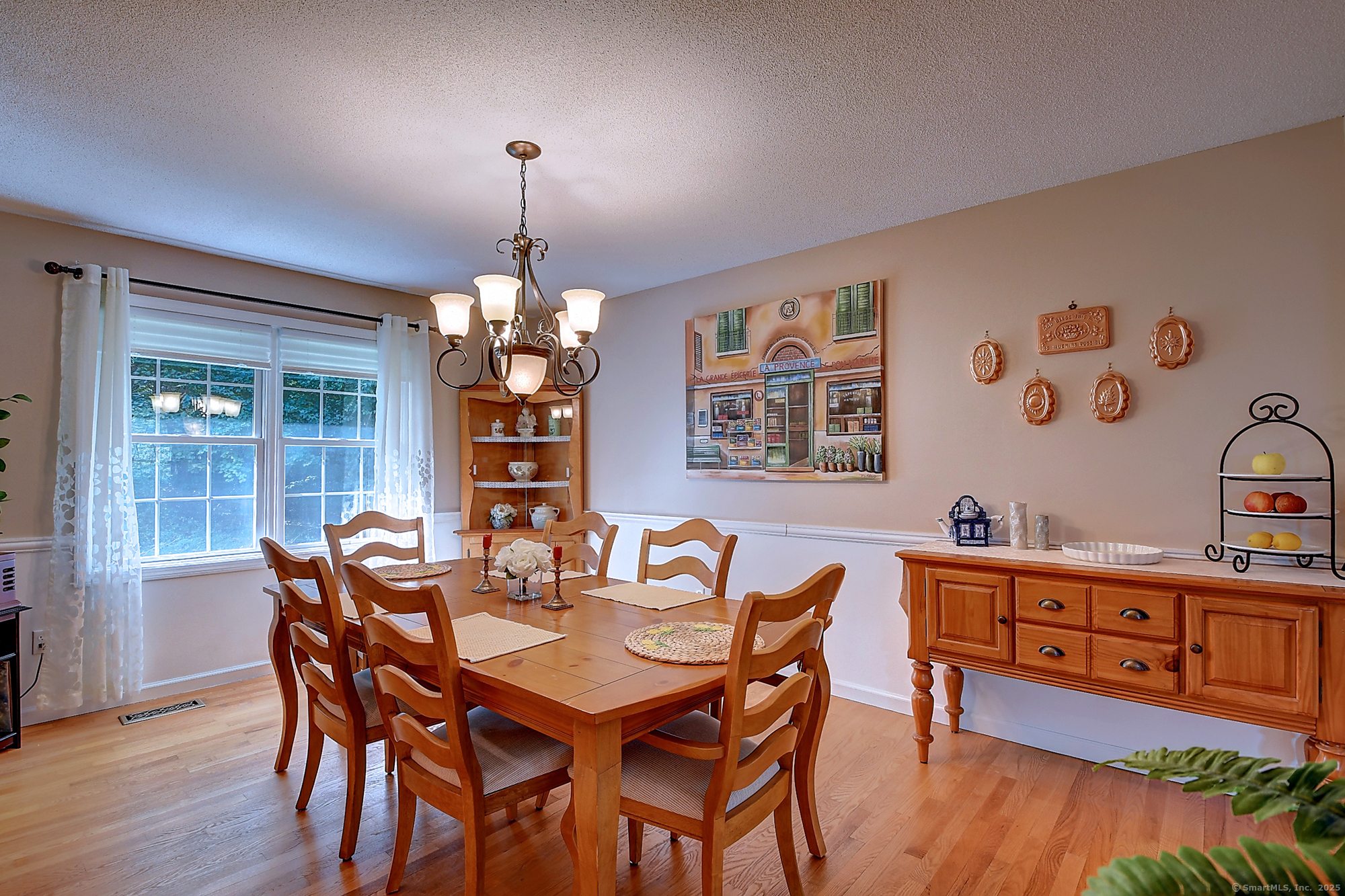 884 Moss Farms Road Cheshire, CT 06410 - Photo 7 of 39 a dining room with wooden floor a chandelier a wooden table and chairs
