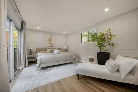 a bedroom with furniture and a large window