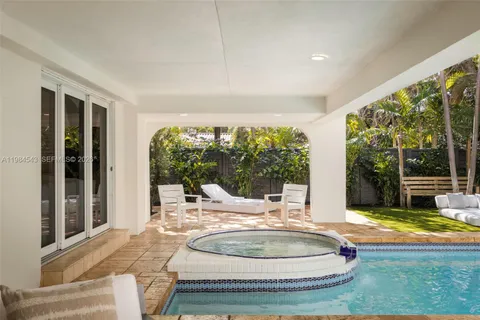 a large swimming pool with a large window and sitting area