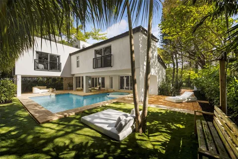 a view of a house with backyard and trees