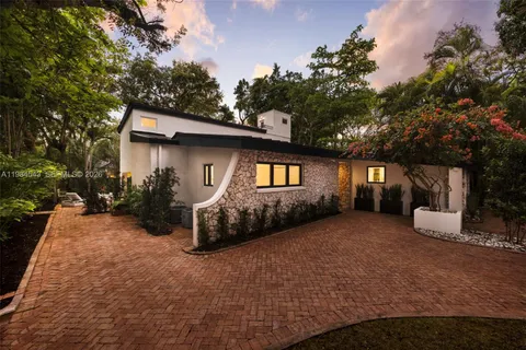 a yellow house with trees in front of it