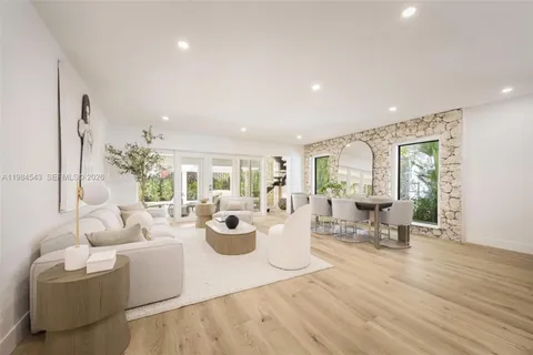 a living room with furniture a mirror and white walls