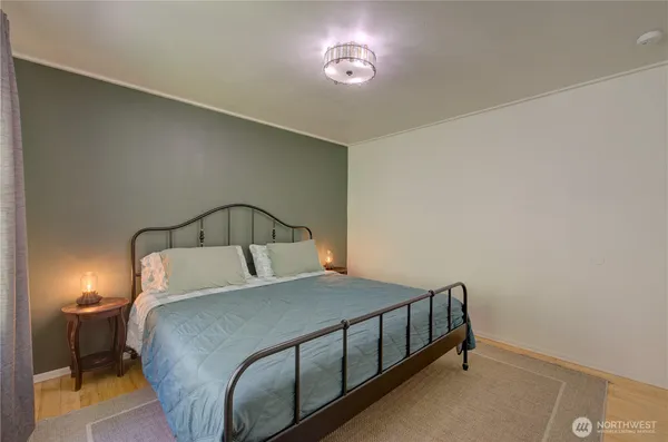 a bedroom with a bed and a lamp on dresser