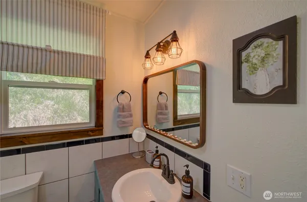 a bathroom with a sink mirror and vanity