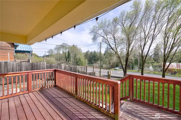 a view of a wooden deck with large trees