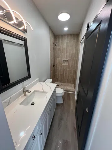 a bathroom with a sink a toilet and a mirror