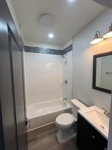 a bathroom with a granite countertop toilet sink and shower