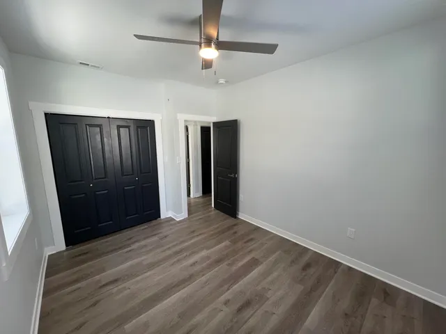 wooden floor in an empty room with a bathroom