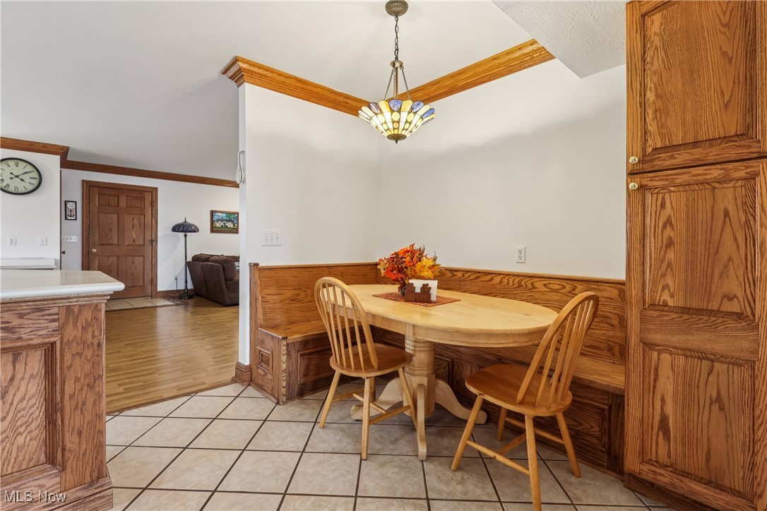 337 Cedar Point Road Sandusky, OH 44870 - Photo 10 of 50 Dining area with crown molding and light tile patterned flooring