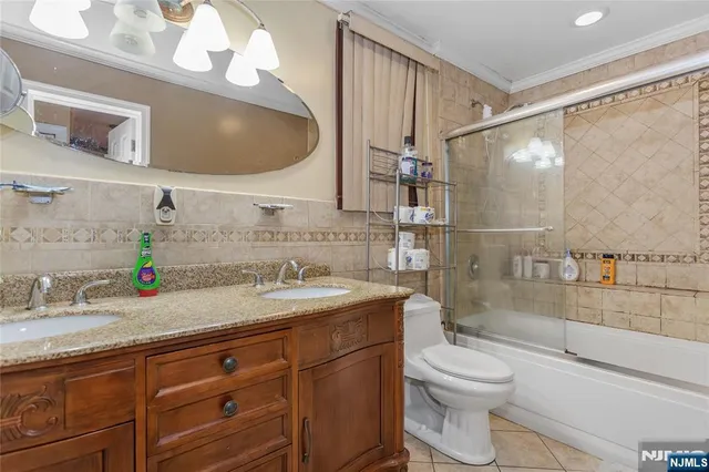 a bathroom with a granite countertop sink a toilet and shower