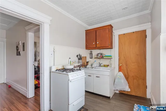 a kitchen with stainless steel appliances granite countertop a sink and cabinets with wooden floor