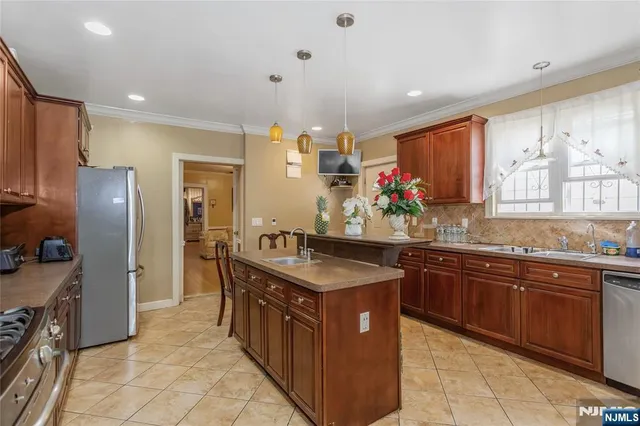 a kitchen with stainless steel appliances granite countertop a sink counter space cabinets and a large window
