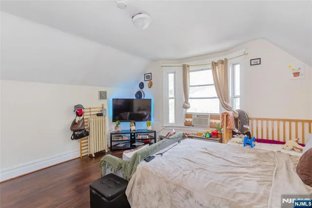 a bed room with a bed a window and a flat screen tv