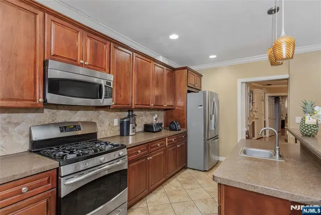 a kitchen with stainless steel appliances granite countertop a stove a refrigerator and a microwave