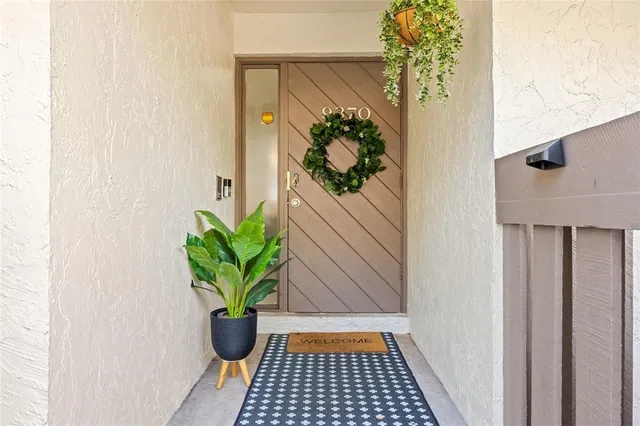 a view of a hallway with wooden floor and a potted plant