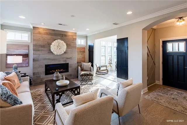 a living room with furniture a fireplace and a large window
