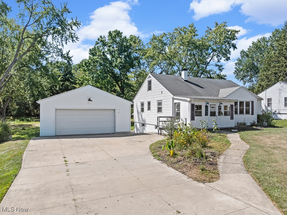 1702 Far View Road Akron, OH 44312 - Photo 37 of 49 View of front facade featuring an outbuilding, a chimney, a detached garage, a front yard, and roof with shingles