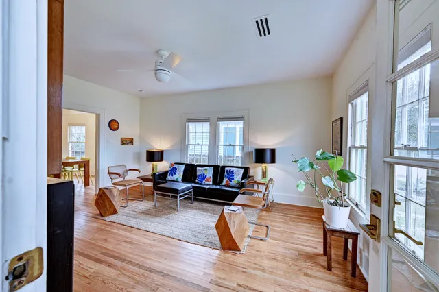 a living room with furniture a flat screen tv and a wooden floor