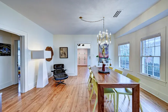 a view of a dining room with furniture a chandelier and wooden floor