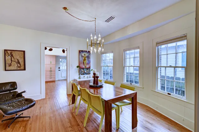 a view of a dining room with furniture a chandelier and wooden floor