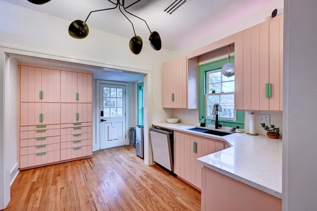a kitchen with stainless steel appliances granite countertop a sink and wooden floors