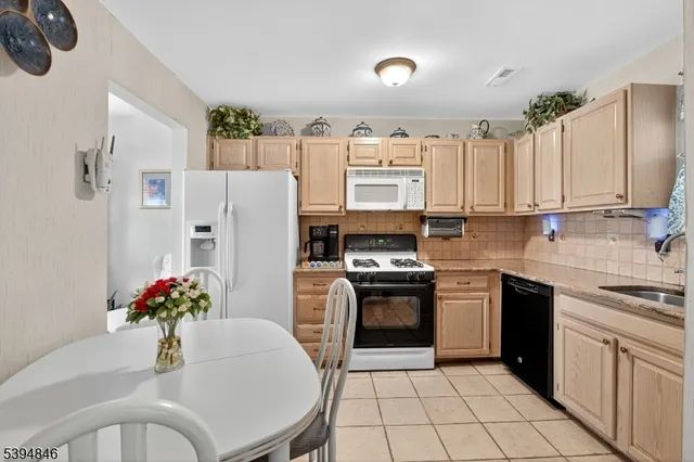 a kitchen with stainless steel appliances a refrigerator sink stove microwave and cabinets