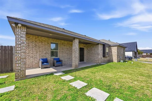 a backyard of a house with yard table and chairs