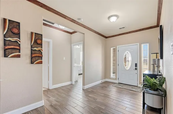 a view of a hallway with wooden floor and table and chairs