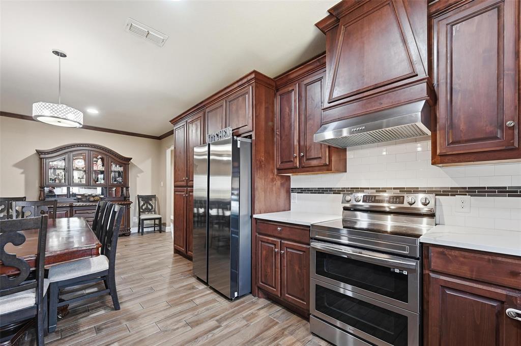 559 Northstar Road Fate, TX 75189 - Photo 10 of 32 a kitchen with stainless steel appliances granite countertop a stove and a refrigerator