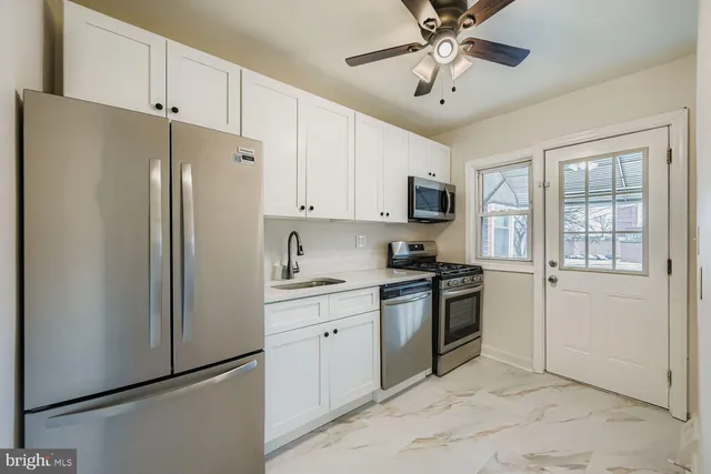 a kitchen with stainless steel appliances granite countertop a refrigerator a stove a sink and a microwave