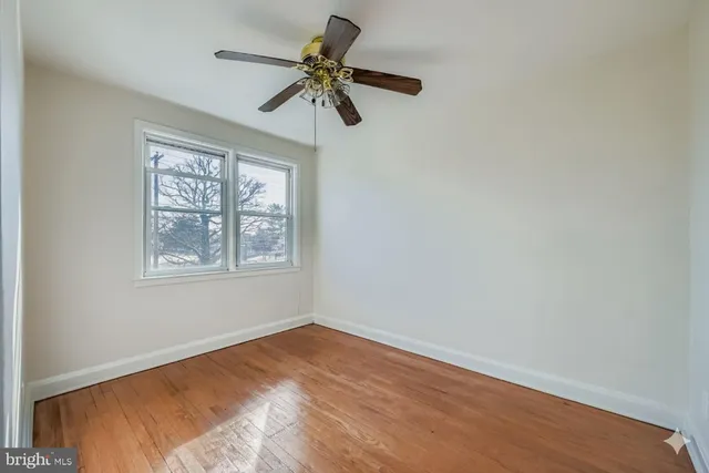 a view of empty room with window and ceiling fan