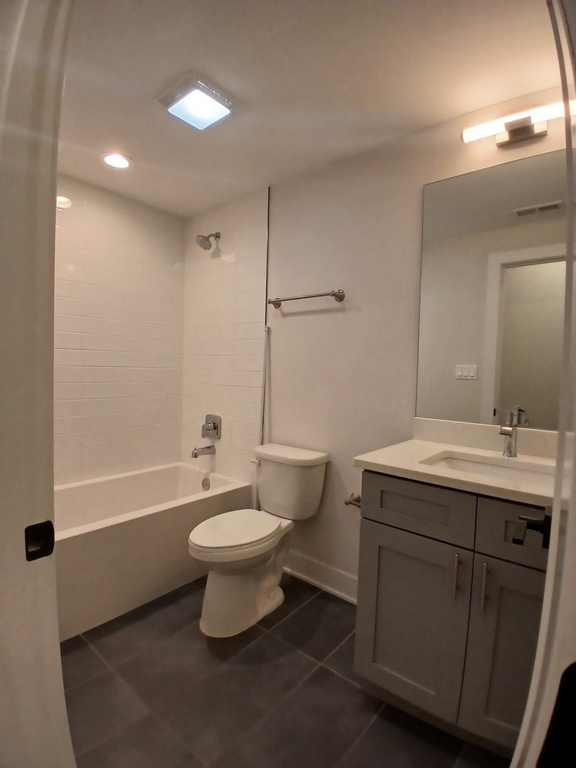 4608 South Indiana Avenue, Unit 1 Chicago, IL 60653 - Photo 17 of 24 a bathroom with a toilet sink and mirror