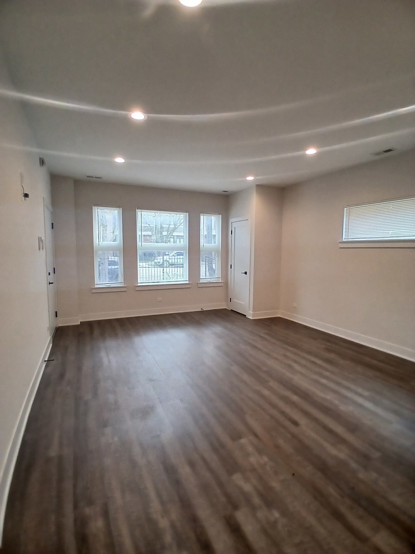 4608 South Indiana Avenue, Unit 1 Chicago, IL 60653 - Photo 2 of 24 wooden floor in an empty room with a window