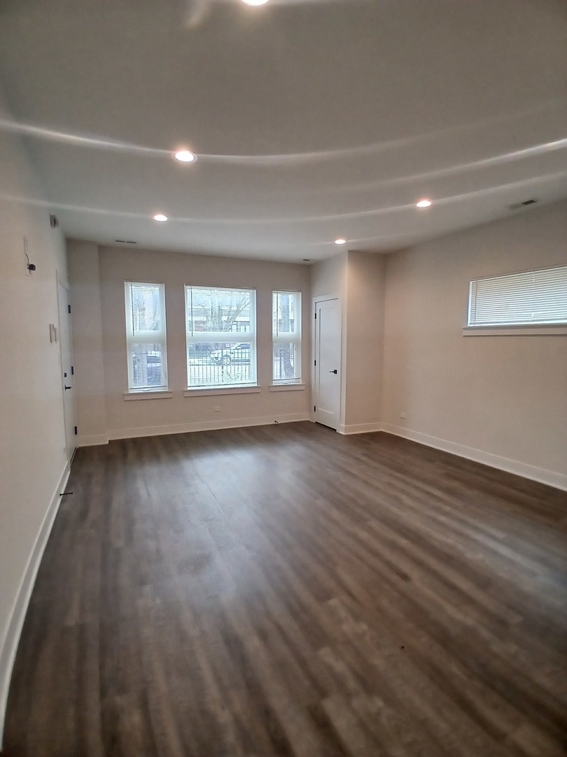 4608 South Indiana Avenue, Unit 1 Chicago, IL 60653 - Photo 3 of 24 an empty room with wooden floor and windows