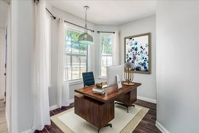 a view of a workspace with furniture and a window