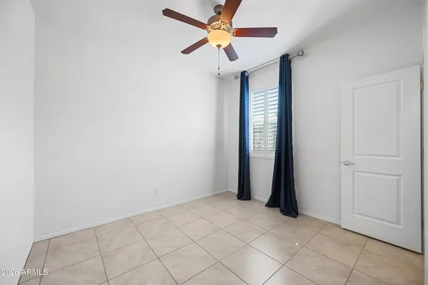 an empty room with closet and a chandelier fan