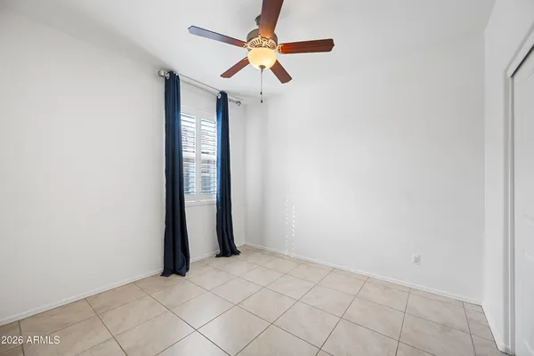an empty room with fan and a window