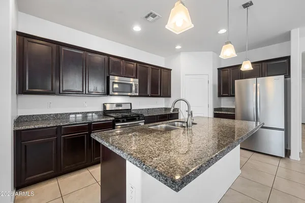 a kitchen with stainless steel appliances granite countertop a sink refrigerator and microwave