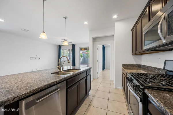 a kitchen with granite countertop stainless steel appliances sink stove and cabinets