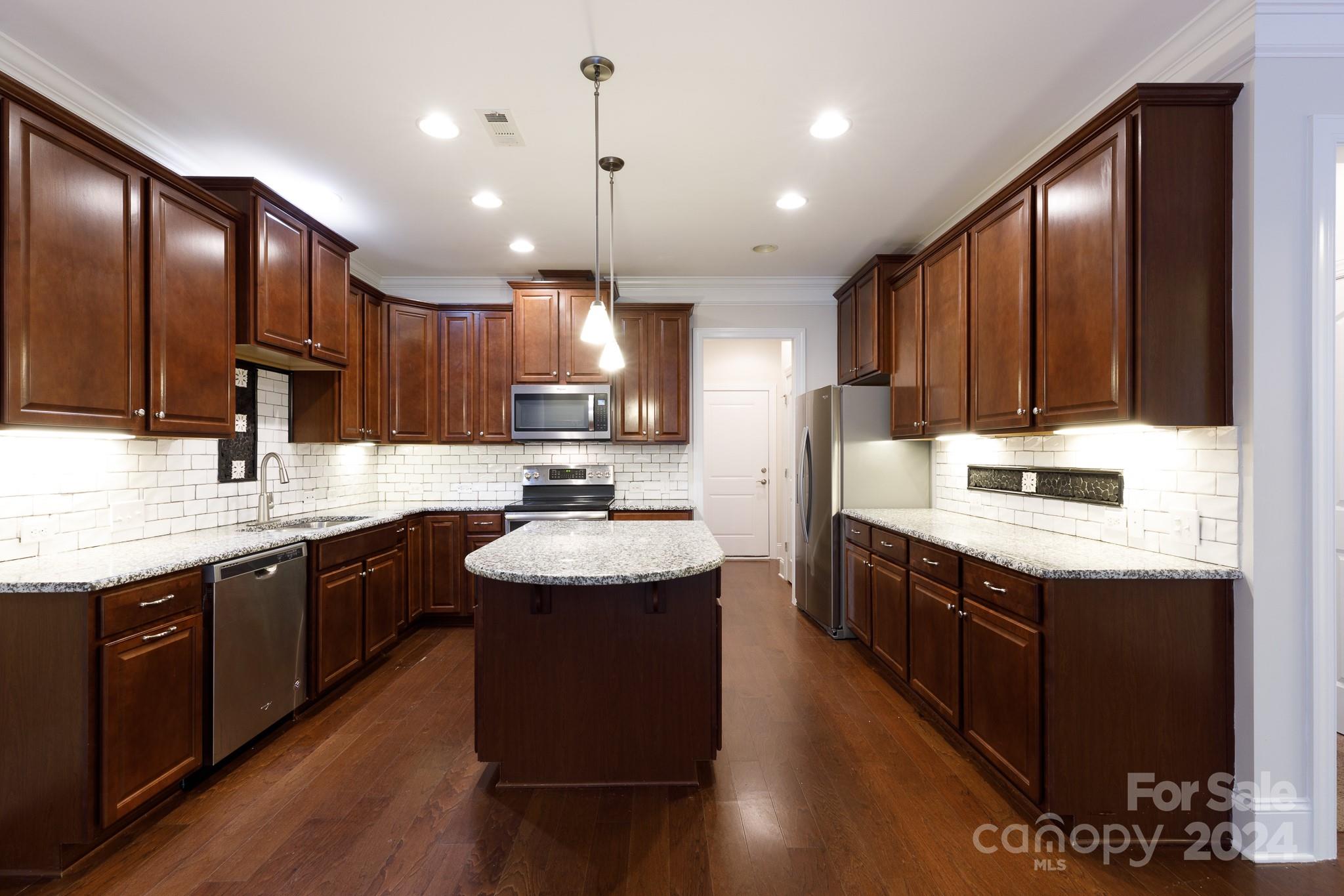 921 Ospre Lane Fort Mill, SC 29708 - Photo 4 of 17 a kitchen with stainless steel appliances granite countertop wooden cabinets sink and stove