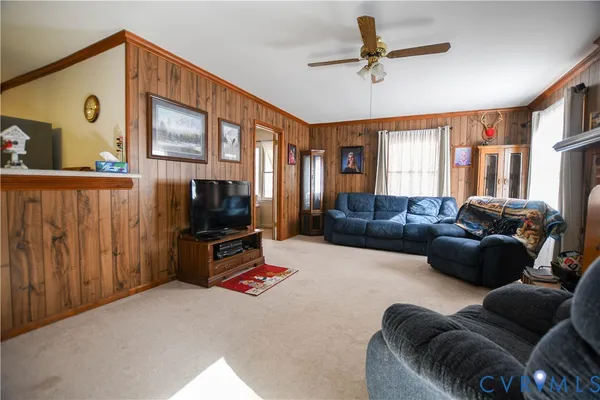 a living room with furniture a window and a flat screen tv