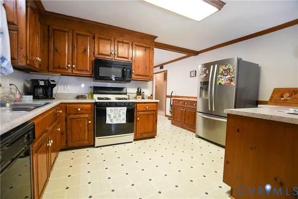 a kitchen with stainless steel appliances a stove a sink and a refrigerator