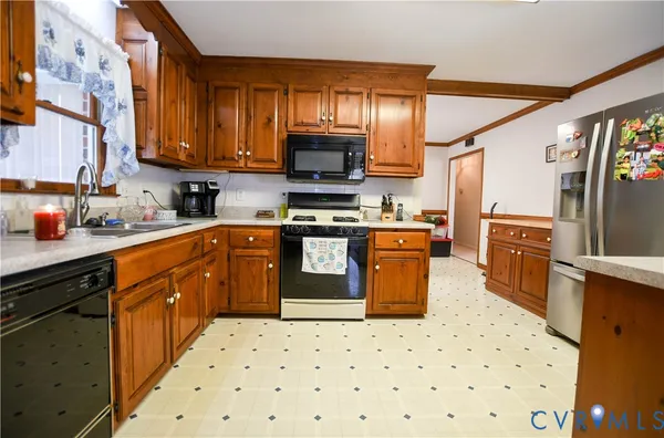 a kitchen with stainless steel appliances a stove a sink dishwasher a refrigerator and cabinets with wooden floor