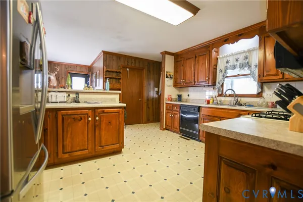 a kitchen with stainless steel appliances a stove a sink and a refrigerator