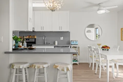a kitchen with stainless steel appliances granite countertop a table and chairs in it