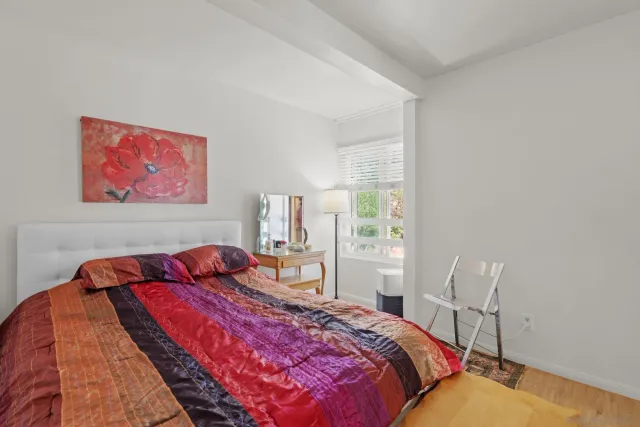 a bedroom with a bed and a painting on the wall