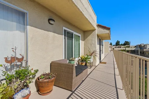 a view of a balcony with chair and potted plants