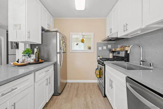 a kitchen with a sink a refrigerator and cabinets